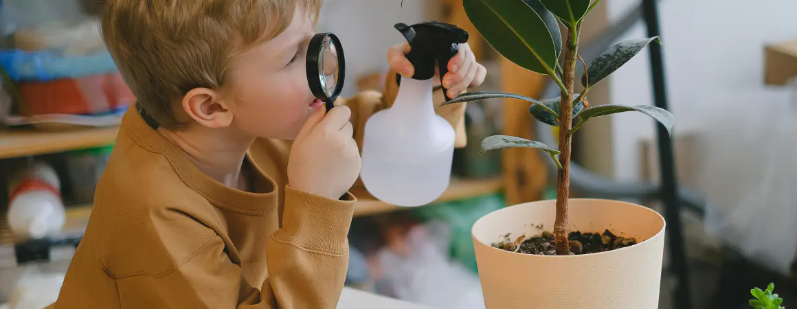 child looking through magnifiying glass