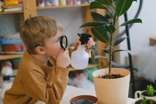 child looking through magnifiying glass