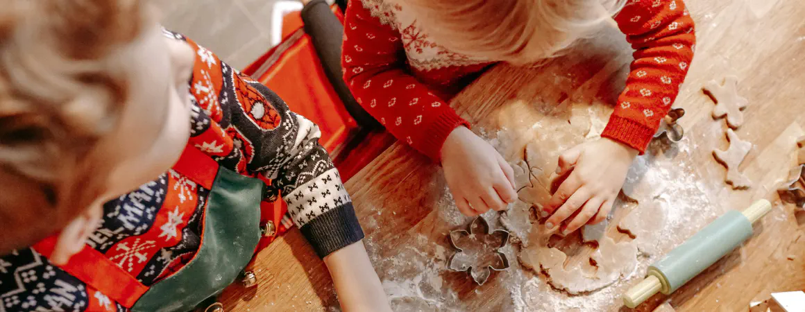 children making christmas cookies in christmas jumpers