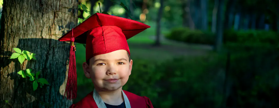 child wearing a graduation cap
